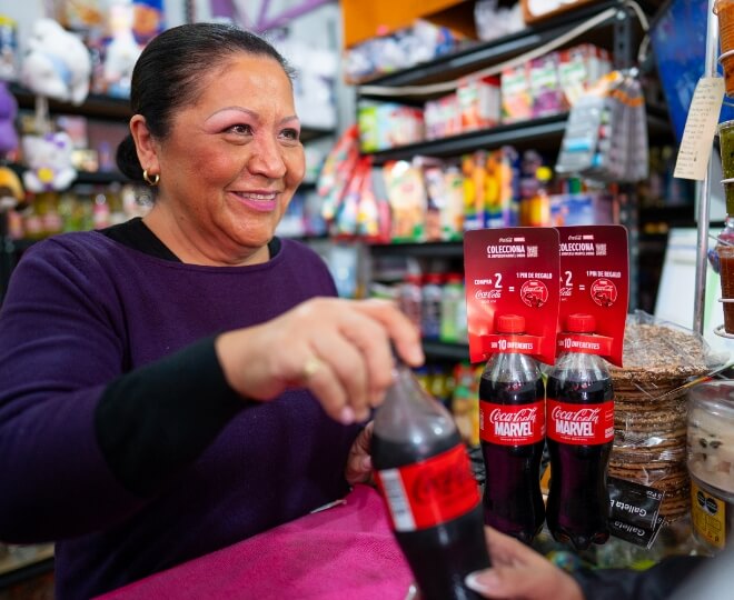 mujer en una tienda con botellas de coca-cola