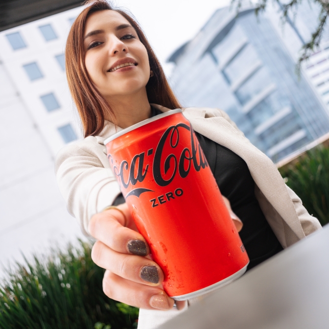 chicos soteniendo latas de coca-cola